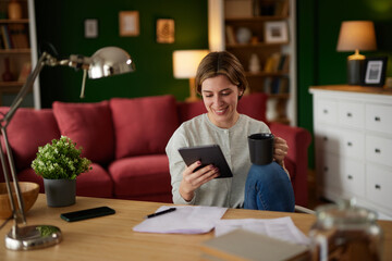 Women using digital tablet to check her finances at home office