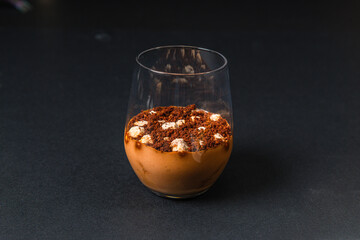 Gastronomic delights of restaurant dishes, chocolate mousse dessert served in a glass isolated on a black background, culinary arts