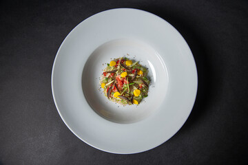 top view of a plate of Gourmet and gastronomic mix of various Vegetables ingredients of entree dish  isolated on a black background, entree dish
