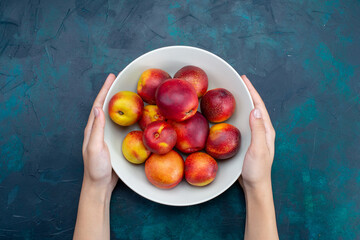 top view fresh mellow peaches inside plate on the dark-blue desk fruit fresh ripe mellow vitamine - obrazy, fototapety, plakaty
