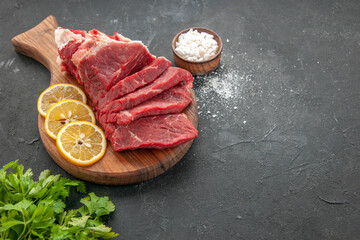 front view fresh sliced meat sliced with lemon slices on a dark background dinner food barbecue...