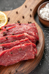 front close view raw meat slices with lemon slices on dark background meal dinner meat butcher salad barbecue food animal