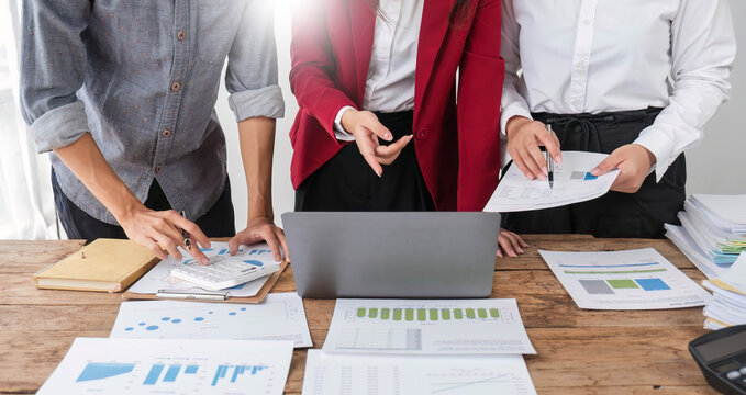 Business People Meeting using laptop computer,calculator,notebook,stock market chart paper for analysis Plans to improve quality next month. Conference Discussion Corporate Concept..