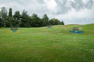 Cestos a meio um campo de golfe para o treino de tacada ao alvo num dia muito nublado - obrazy, fototapety, plakaty