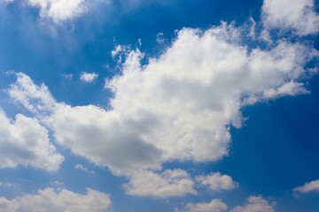 The fluffy white clouds in the bright blue sky.
