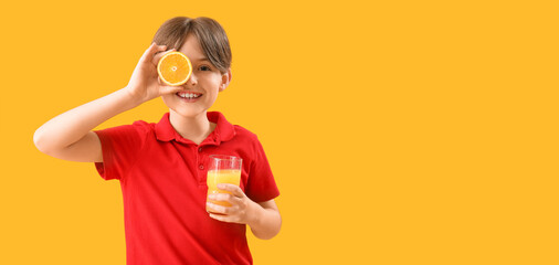 Little boy with glass of orange juice on yellow background with space for text