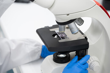 Close up scientist looking to microscope eyepiece in clinical laboratory.Young scientist doing some...