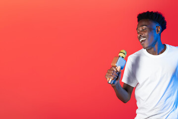 Charismatic black man singer performing on red, copy space