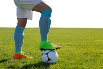 Digital png photo of legs of hispanic footballer with ball on transparent background
