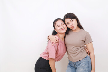 Two young beautiful smiling asian female on white background. Friendship concept