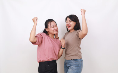 Two confident asian women standing while clenching hands. Isolated on white background