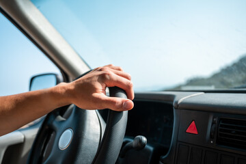 A hand on the wheel of a van.