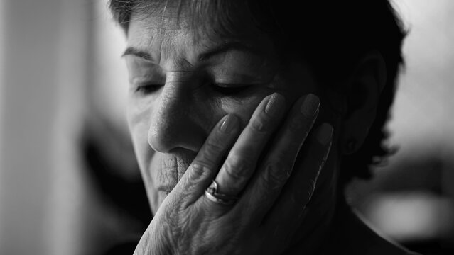 Preoccupied senior woman feeling worry and loneliness in monochrome black and white. Thoughtful pensive expression of an older person in contemplation