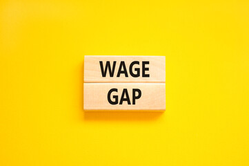 Naklejka premium Wage gap symbol. Concept words Wage gap on wooden blocks on a beautiful yellow table yellow background. Business, support and wage gap concept. Copy space.