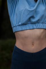 View of athletic body of a girl in blue gym suit in cloudy  weather.