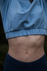 View of athletic body of a girl in blue gym suit in rainy weather.