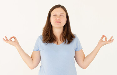 Mindful caucasian pregnant woman meditates indoor, keeps hands in mudra gesture, has eyes closed,...