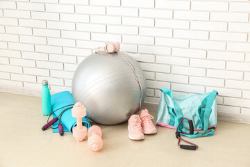 Sports equipment with bag near white brick wall