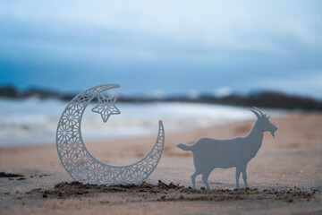 Eid Mubarak concept photo crescent moon with goat on the beach