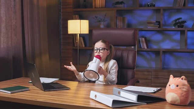 Little Business Executive Sitting At Long Wooden Table And Shouting On Megaphone In Fancy Workplace. Adorable Blonde Kid With Two Long Ponytails Announcing Important Information For Company Employees.