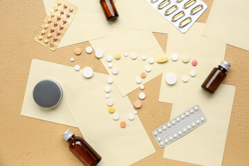 Uterus made of pills, medications and paper sheets on beige background