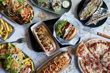 Variety of junk food dishes on the table. Hot dogs, French fries, salchipapas