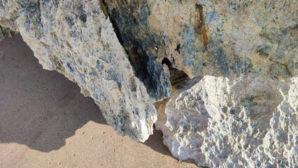 Rocks and beach sand during the day in the beach area