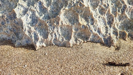 Fototapeta na wymiar Rocks and beach sand during the day in the beach area