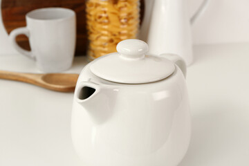 Composition with teapot, cup and different items on white table