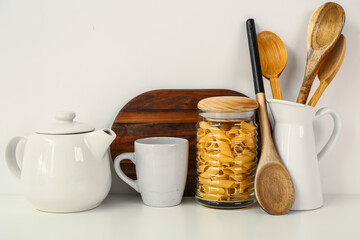 Composition with teapot, cup and different items on white table