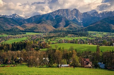 Fototapeta na wymiar Beautiful country view with mountains in the background. View of the Tatra Mountains and Koscielisko Village in Poland.