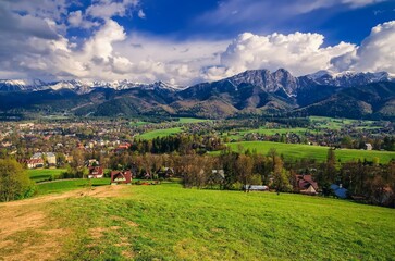 Beautiful country view with mountains in the background. View of the Tatra Mountains, Zakopane Town and Koscielisko Village in Poland. - obrazy, fototapety, plakaty