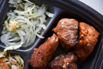 Meat appetizer with onions and cabbage. Barbecue with vegetables. Meat lunch.