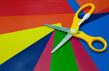 colorful paper background. Sheets of colored paper, iridescent palette of colored paper, rainbow colors. Top view table with colored paper and scissors.