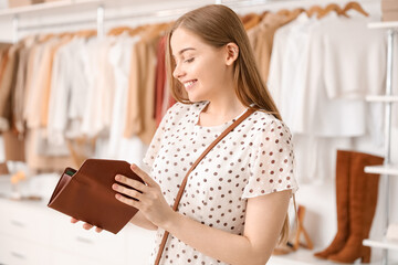 Young woman with wallet in boutique