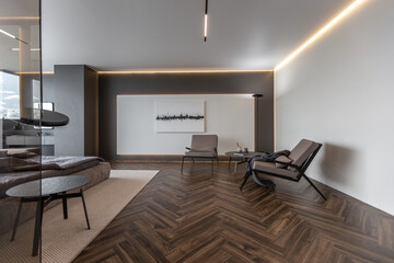cool expensive interior design of room in prestigious luxury hotel with dark tones with modern LED lighting and stylish furniture. the area with a sink is separated by dark glass from the bedroom