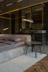 cool expensive interior design of room in prestigious luxury hotel with dark tones with modern LED lighting and stylish furniture. the area with a sink is separated by dark glass from the bedroom