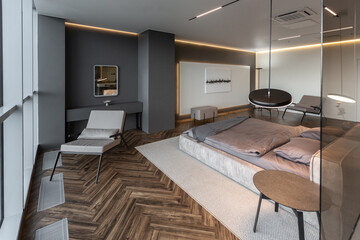 cool expensive interior design of room in prestigious luxury hotel with dark tones with modern LED lighting and stylish furniture. the area with a sink is separated by dark glass from the bedroom