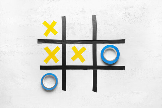 Tic-tac-toe game made of adhesive tapes on white background