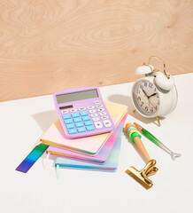 Time management concept. Retro vintage alarm clock, colorful notebooks to write down the necessary information, pens, colorful ruler. Idea of office work.