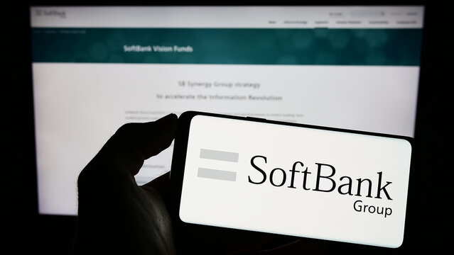 Stuttgart, Germany - 06-16-2023: Person holding smartphone with logo of Japanese investment company SoftBank Group Corp. on screen in front of website. Focus on phone display.