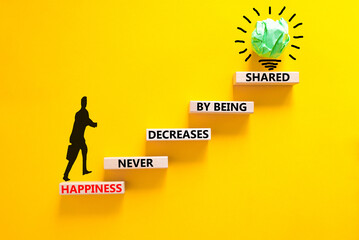 Happiness symbol. Concept words Happiness never decreases by being shared on wooden block. Beautiful yellow table yellow background. Businessman icon. Motivational Happiness concept. Copy space.