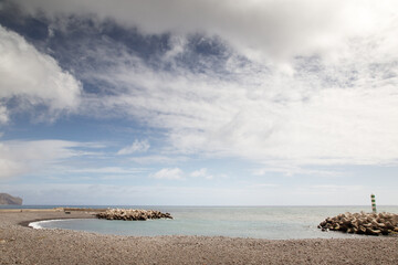 small beacon light on seashore in madeira