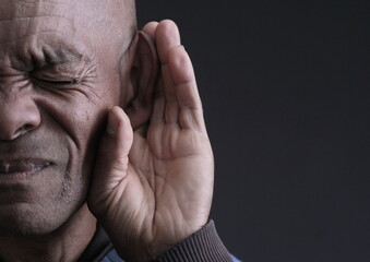deaf man suffering from deafness and hearing loss on grey background with people stock photo