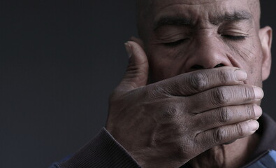 praying to God with hands over mouth on grey black background with people stock photo