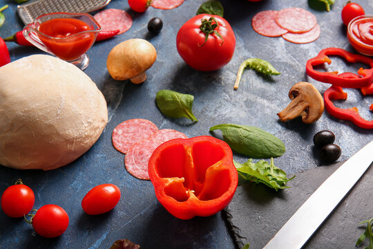 Different ingredients for preparing pizza on blue background