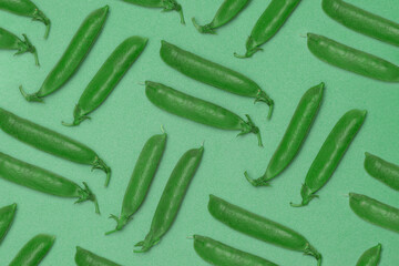 green pea pod group lies on green background