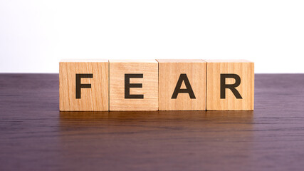 fear written in wooden cubes. conceptual word collected of of wooden elements with the letters. stock image, brown background