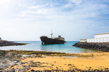 The Telamon shipwreck on the sea under a blue sky and sunlight in Lanzarote Island , Spain