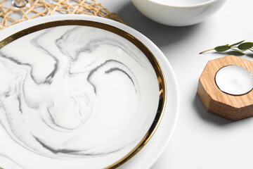 Beautiful table setting and candle on white background, closeup